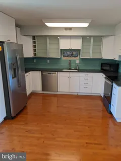 a large kitchen with stainless steel appliances a refrigerator and a stove top oven
