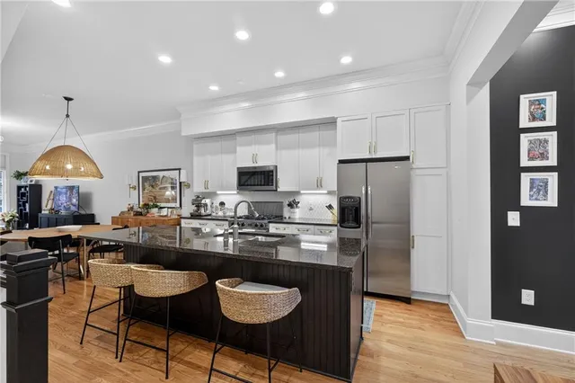 a kitchen with kitchen island granite countertop wooden cabinets and refrigerator