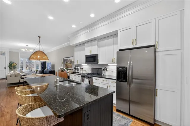 a kitchen with stainless steel appliances granite countertop a sink a stove and a refrigerator