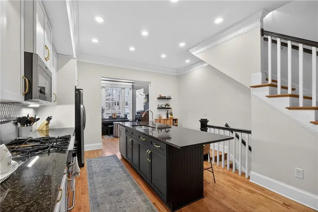a kitchen with stainless steel appliances granite countertop a sink stove and refrigerator