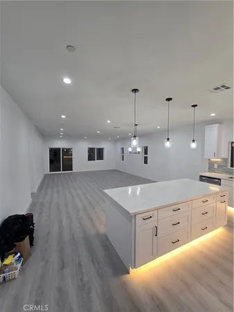 a large kitchen with kitchen island a sink a stove and a refrigerator