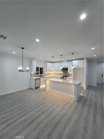 a kitchen with a refrigerator and white cabinets
