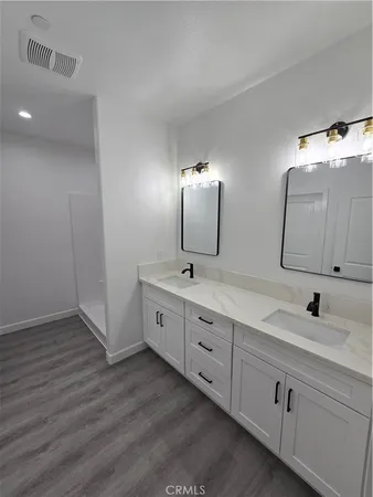 a bathroom with double vanity sink and mirror
