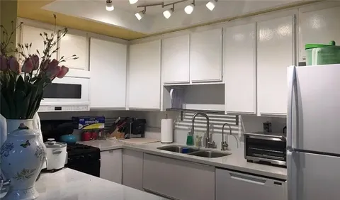 a kitchen with appliances a sink and cabinets