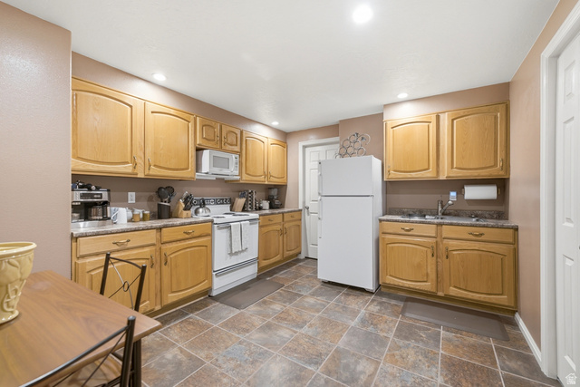 5196 Rodeo Circle Oakley, UT 84055 - Photo 38 of 57 Spacious kitchen featuring light wood cabinetry, stone-finish countertops, and a white freestanding refrigerator