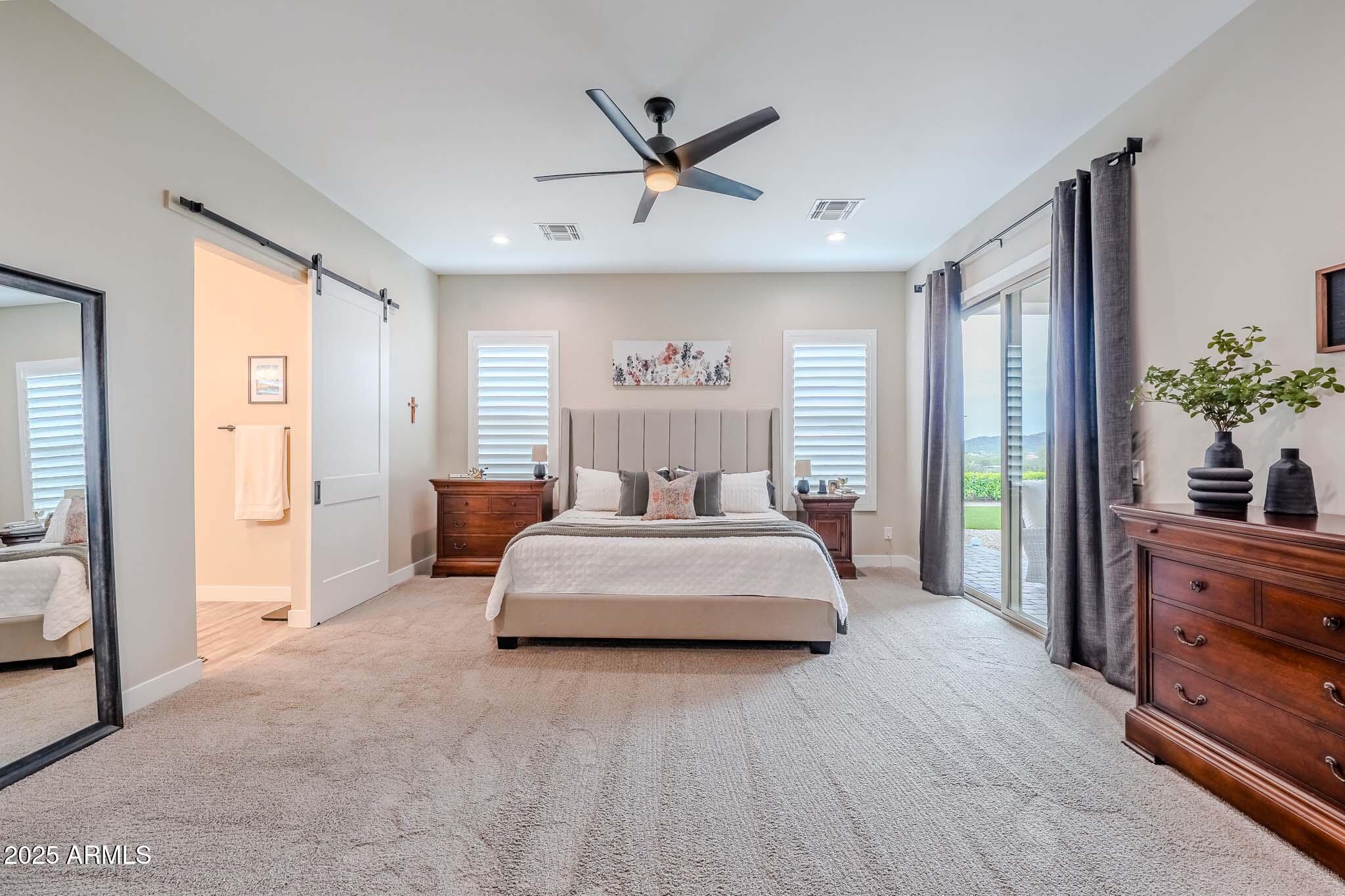 2049 East Gaffney Road New River, AZ 85087 - Photo 25 of 77 a spacious bedroom with a large bed and a chandelier fan