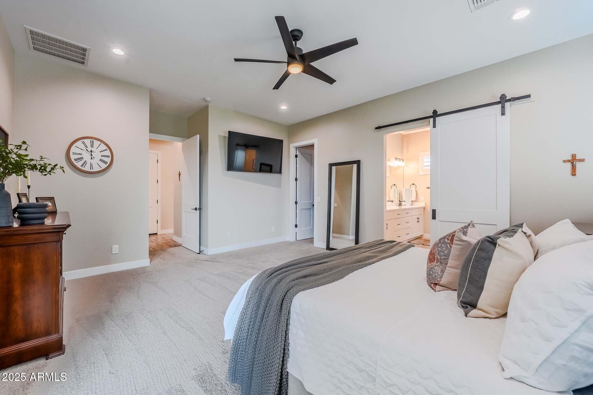 2049 East Gaffney Road New River, AZ 85087 - Photo 26 of 77 a bedroom with a large bed and a ceiling fan