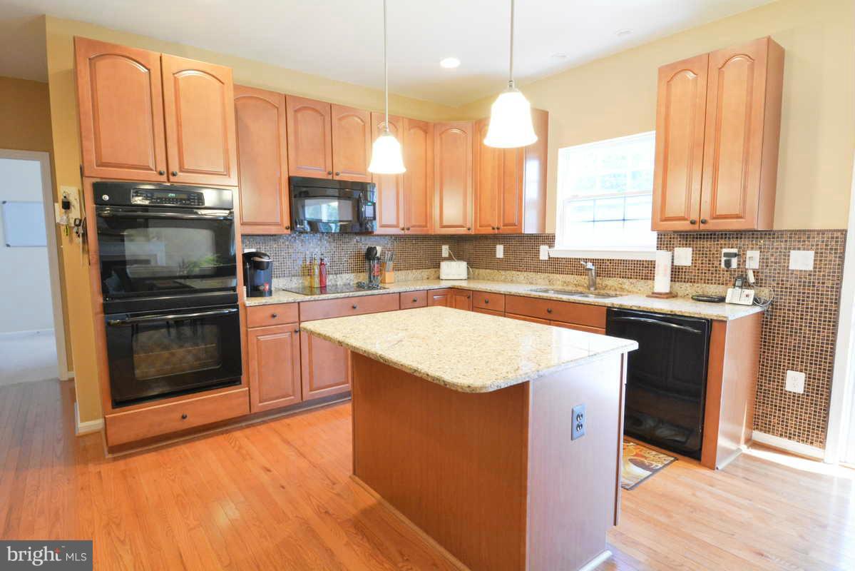 2016 Baythorne Road Prince Frederick, MD 20678 - Photo 11 of 30 a kitchen with a sink a stove a microwave and cabinets