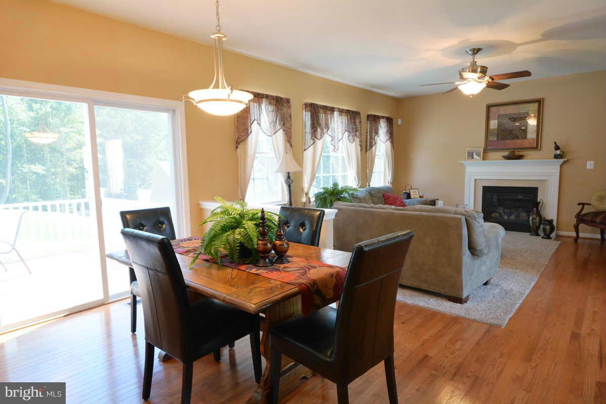 2016 Baythorne Road Prince Frederick, MD 20678 - Photo 14 of 30 a dining room with furniture a fireplace and wooden floor