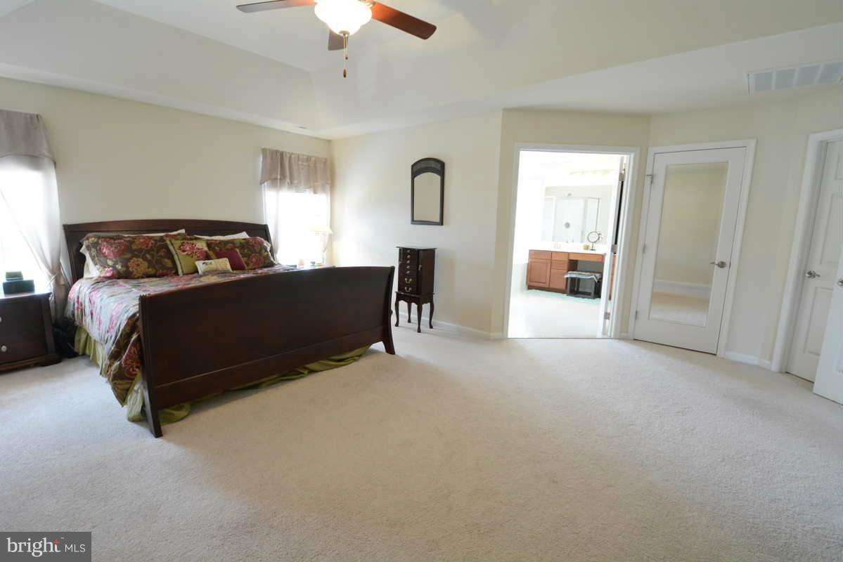 2016 Baythorne Road Prince Frederick, MD 20678 - Photo 18 of 30 a bedroom with a bed lamp and a fireplace