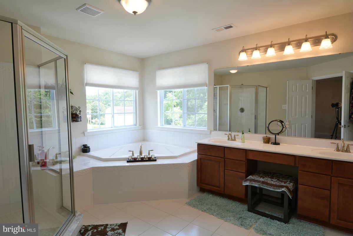 2016 Baythorne Road Prince Frederick, MD 20678 - Photo 19 of 30 a room with a double vanity sink mirror and a bathtub