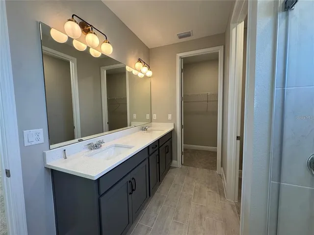a bathroom with a double vanity sink and a mirror