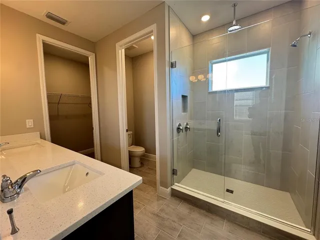 a bathroom with a sink a shower and a mirror