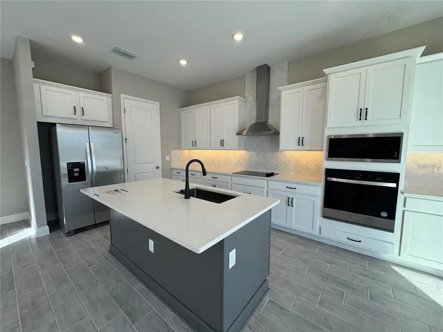 a kitchen with stainless steel appliances a white stove top oven and refrigerator