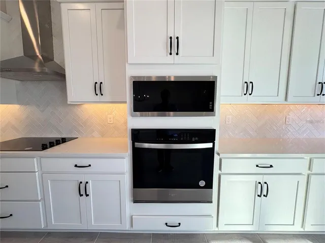 a kitchen with granite countertop white cabinets and oven