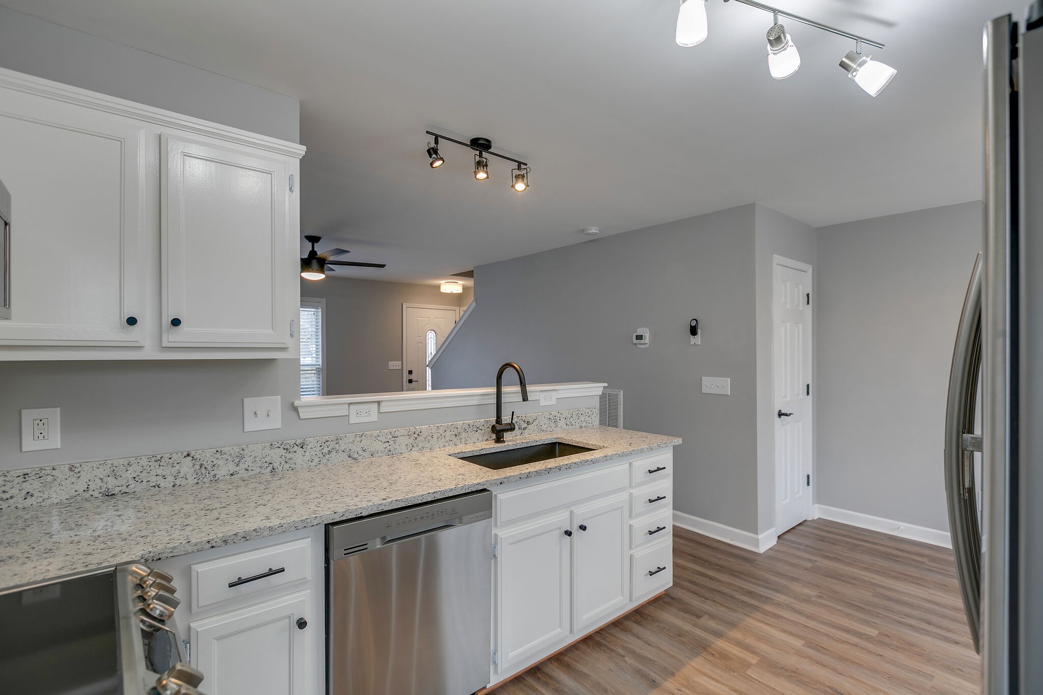 2805 Rippavilla Way Spring Hill, TN 37174 - Photo 12 of 30 a kitchen with stainless steel appliances granite countertop a sink dishwasher and white cabinets with wooden floor