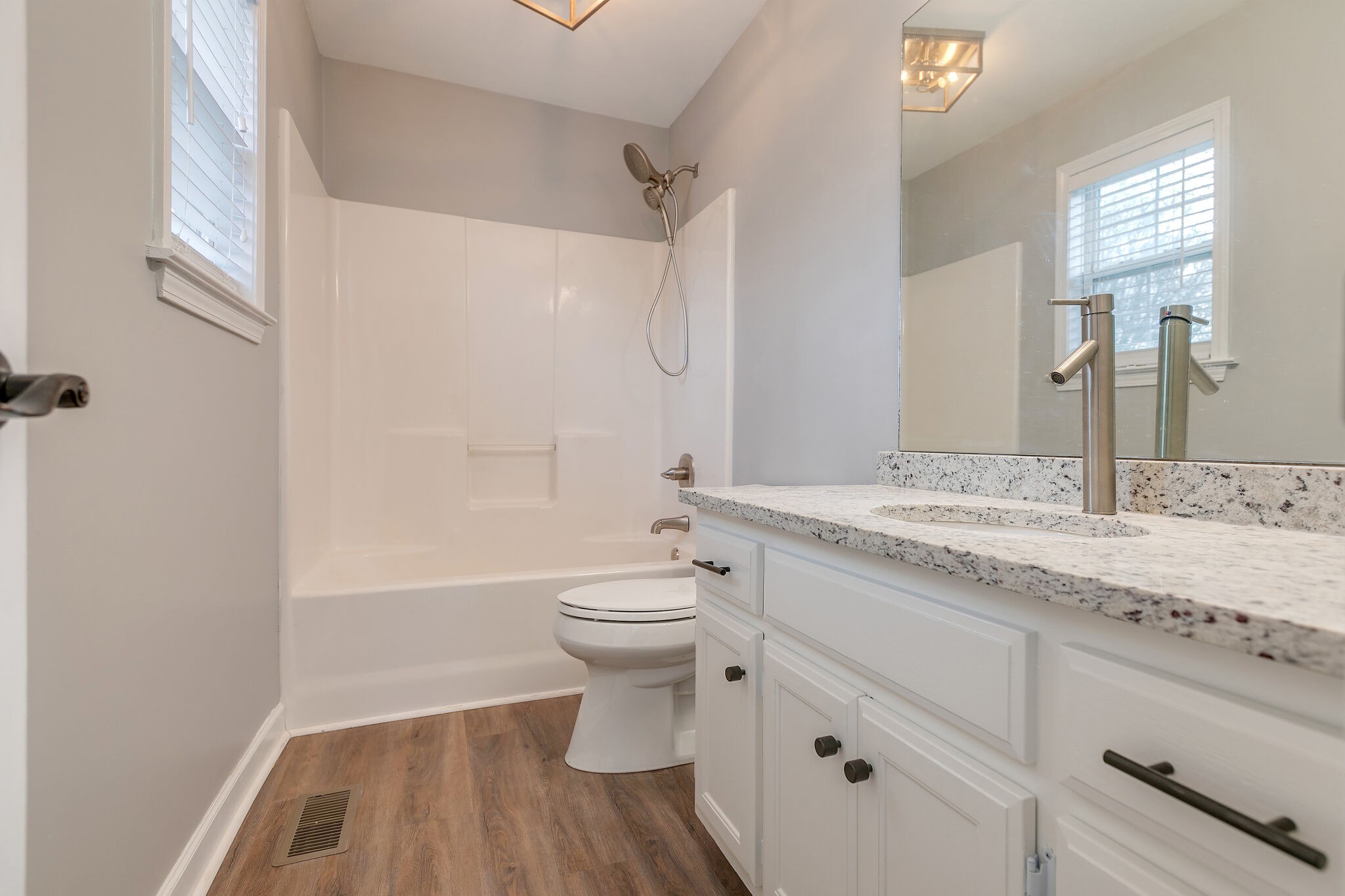 2805 Rippavilla Way Spring Hill, TN 37174 - Photo 17 of 30 a bathroom with a granite countertop sink toilet a large mirror a bathtub and shower