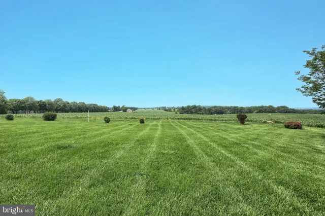 a living room with furniture large window and wooden floor