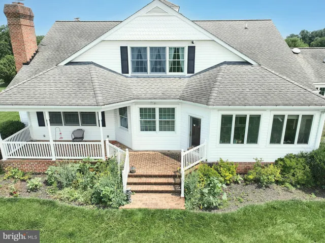 a front view of a house with a yard and potted plants