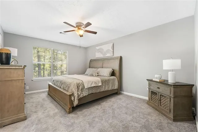 a spacious bedroom with a bed and a chandelier