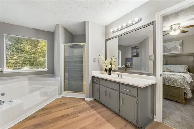 a spacious bathroom with a tub sink and mirror