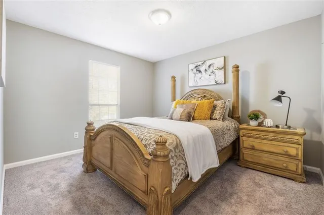 a bedroom with a bed and painting on the wall