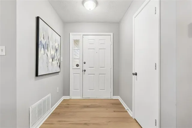 a view of a hallway with wooden floor and closet