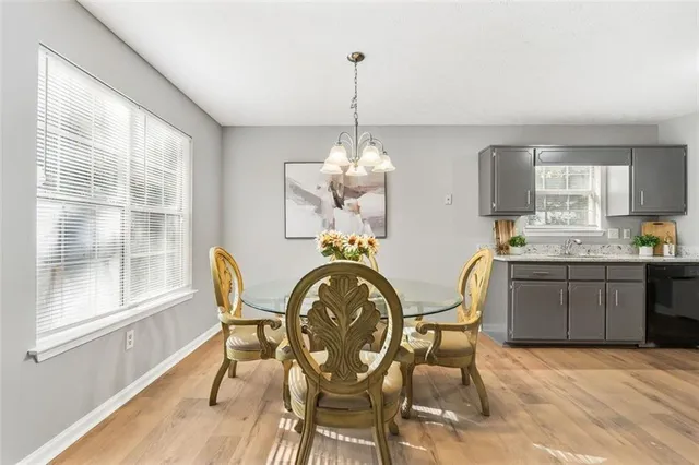 a dining room with furniture a chandelier and wooden floor