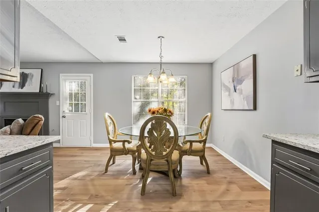 a dining room with furniture a chandelier and wooden floor