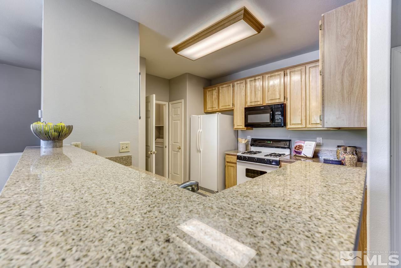900 S, Unit 2024 Reno, NV 89521 - Photo 14 of 32 a kitchen with stainless steel appliances granite countertop a stove refrigerator sink and dishwasher