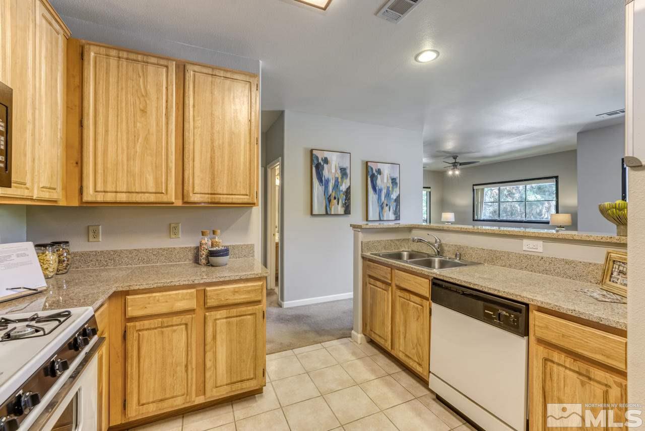 900 S, Unit 2024 Reno, NV 89521 - Photo 18 of 32 a kitchen with stainless steel appliances granite countertop a stove a sink and a refrigerator