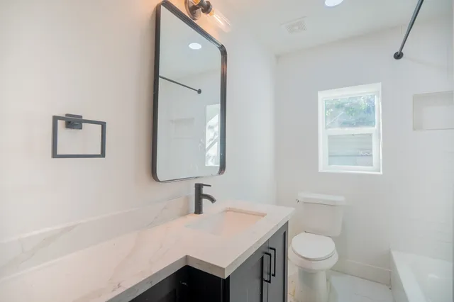 a bathroom with a sink toilet a mirror and vanity
