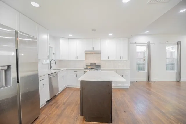 a large kitchen with stainless steel appliances lots of counter top space and a refrigerator