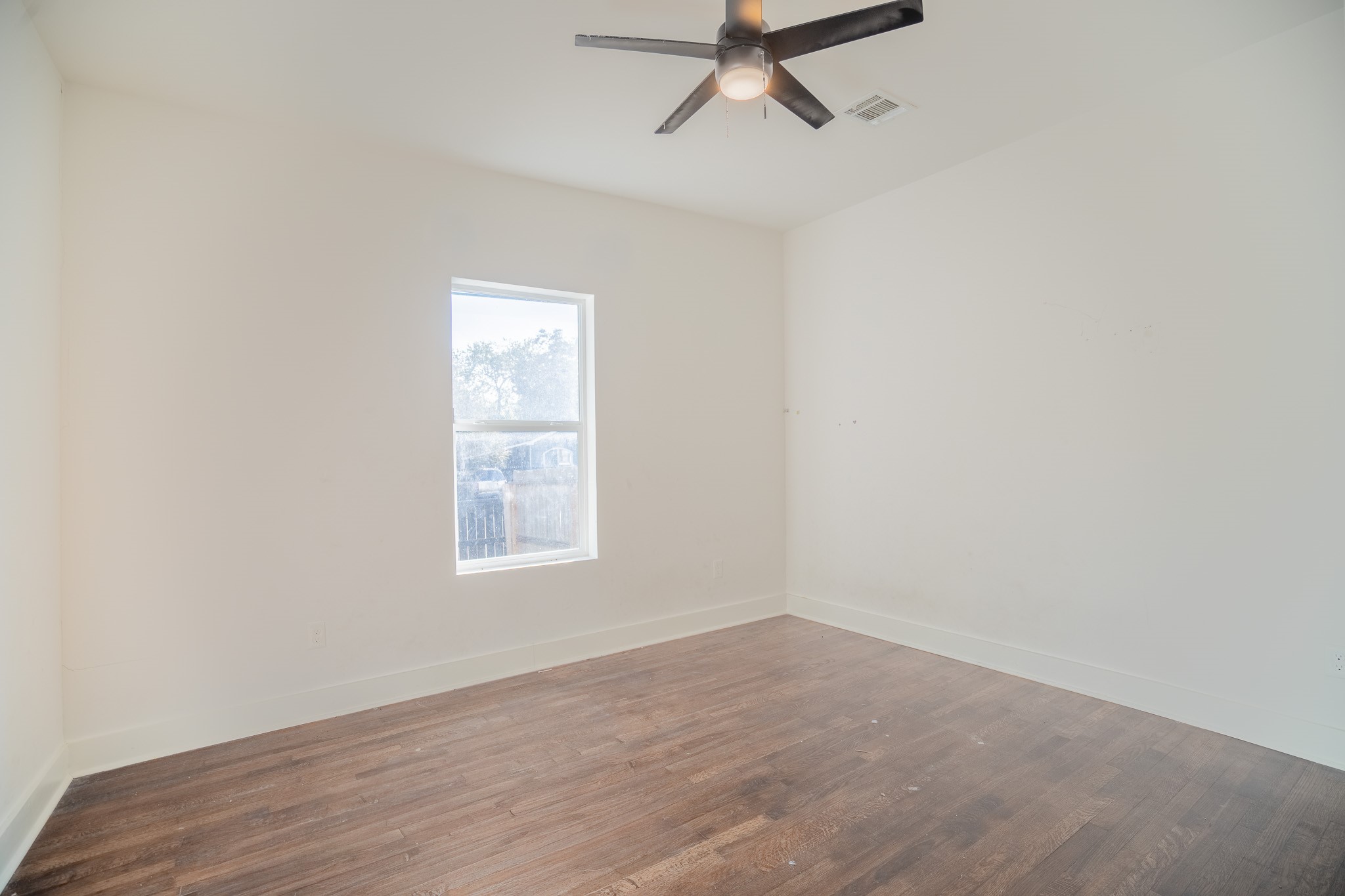 7305 Capitol Street Houston, TX 77011 - Photo 10 of 16 an empty room with a window and a fan