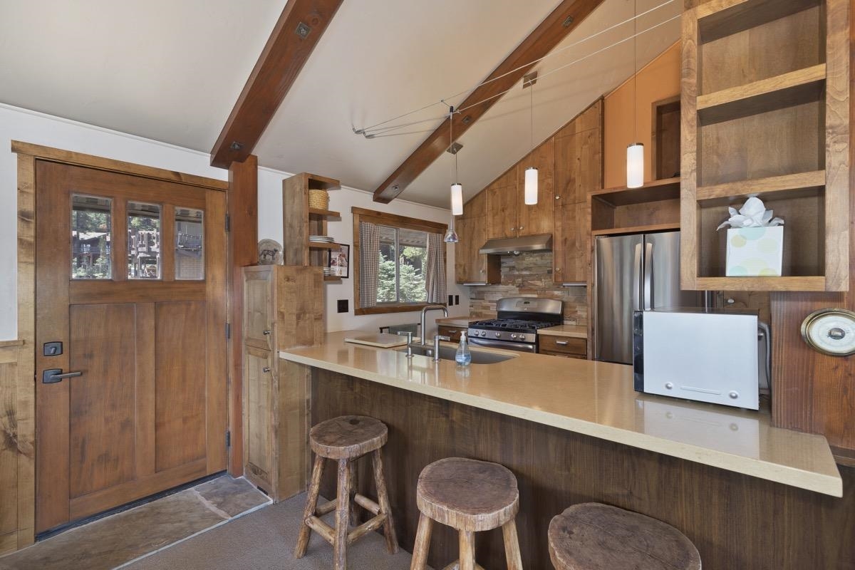 210 Convict Drive Mammoth Lakes, CA 93546 - Photo 27 of 46 a kitchen with a table chairs stove and refrigerator