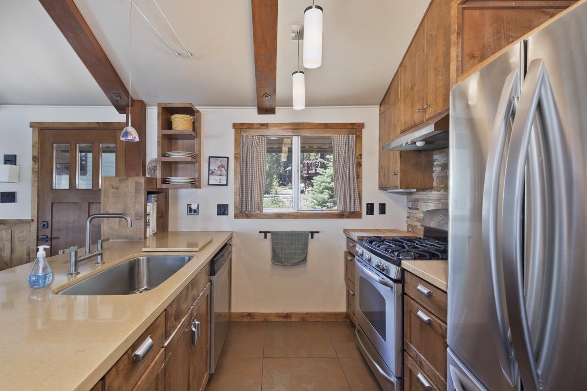 210 Convict Drive Mammoth Lakes, CA 93546 - Photo 28 of 46 a kitchen with stainless steel appliances granite countertop a sink stove and refrigerator