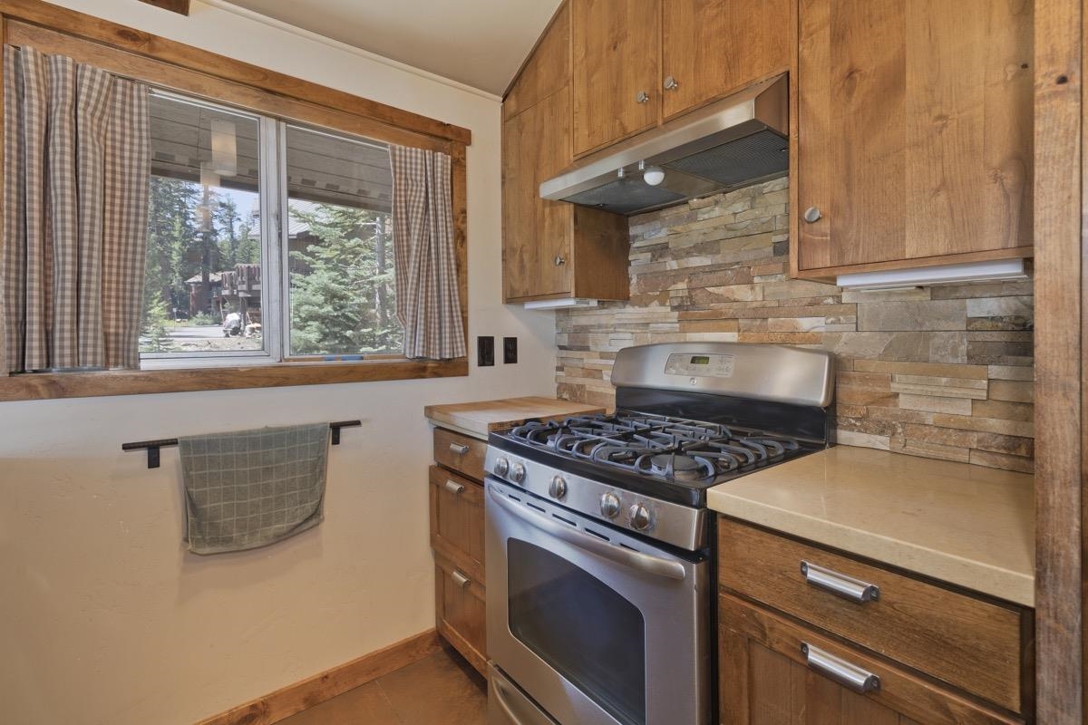 210 Convict Drive Mammoth Lakes, CA 93546 - Photo 29 of 46 a kitchen with granite countertop a stove and a white cabinet