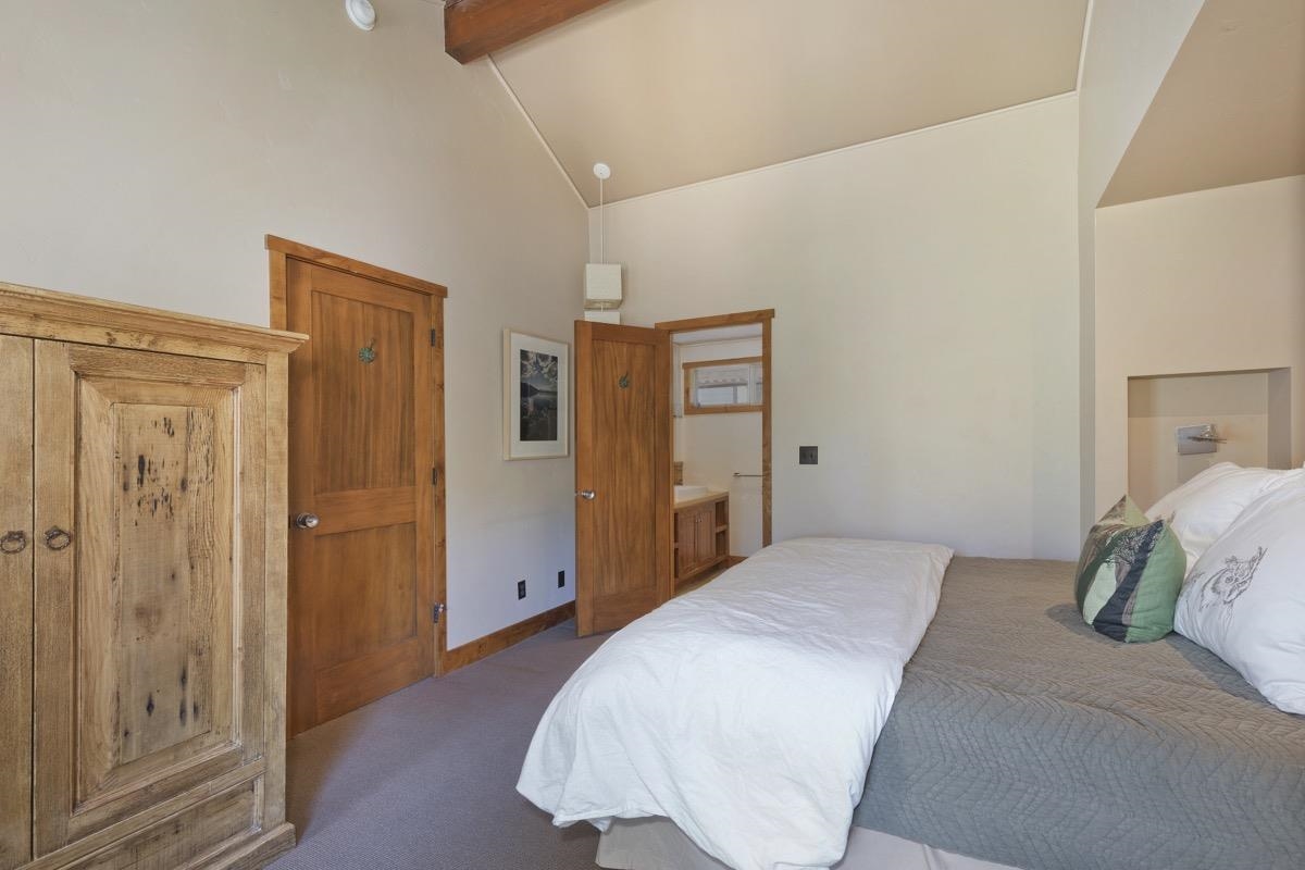 210 Convict Drive Mammoth Lakes, CA 93546 - Photo 32 of 46 a bedroom with a bed and wooden floor