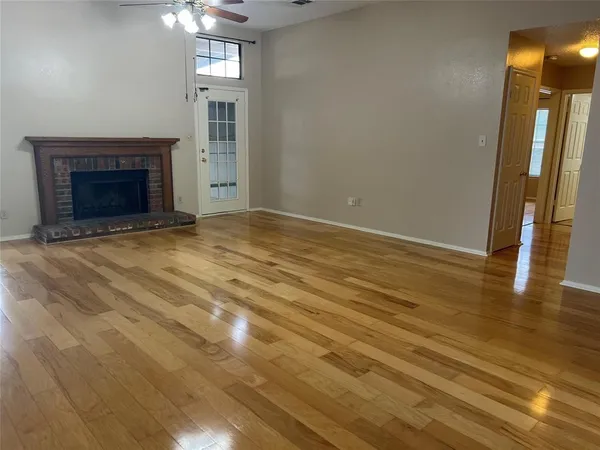 an empty room with wooden floor and fireplace