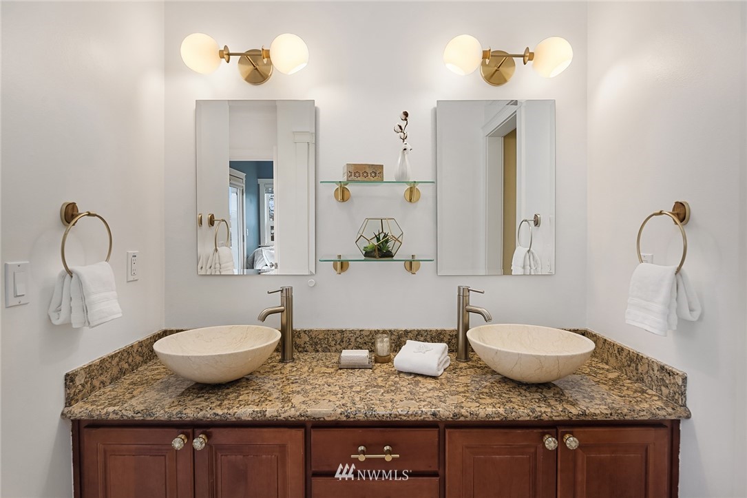 912 North 68th Street Seattle, WA 98103 - Photo 20 of 38 a bathroom with a granite countertop sink and a mirror