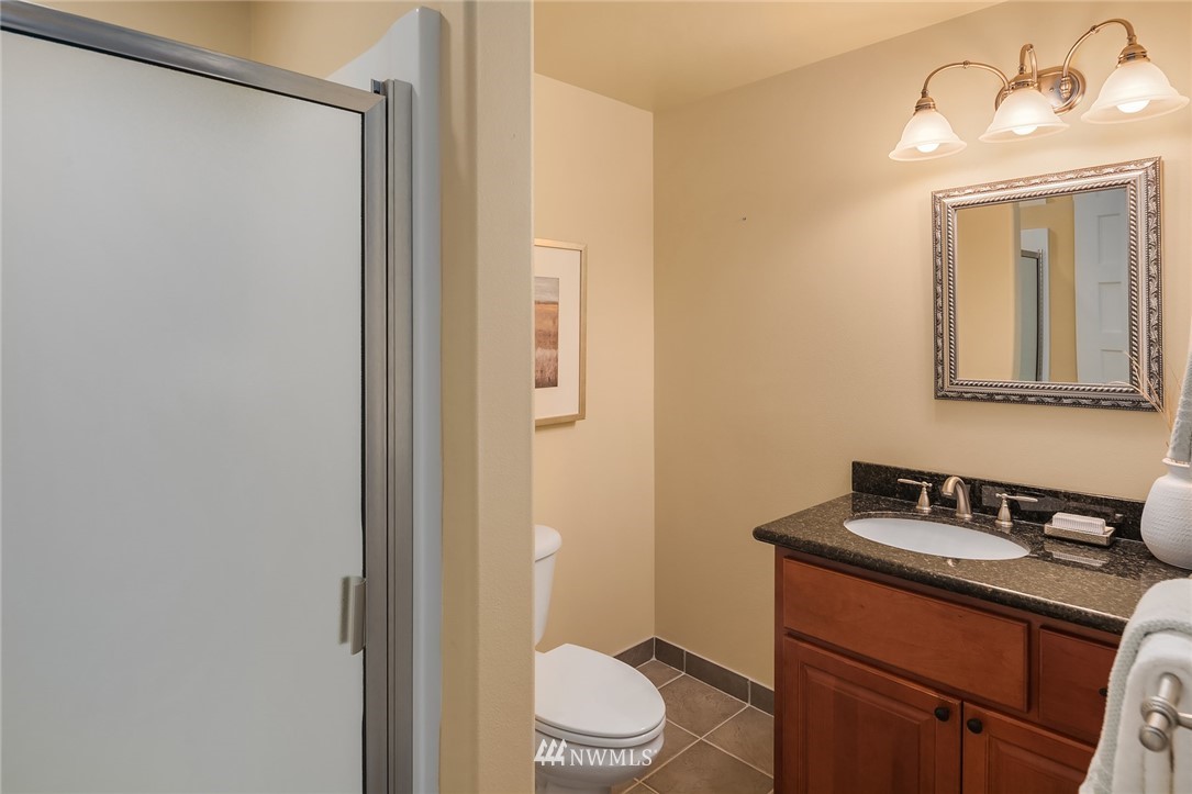 912 North 68th Street Seattle, WA 98103 - Photo 30 of 38 a bathroom with a granite countertop sink toilet and shower