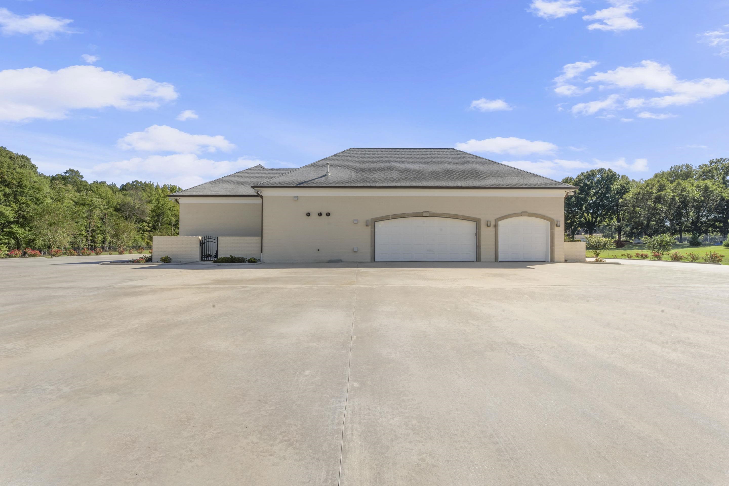 881 Bray Station Road Collierville, TN 38017 - Photo 31 of 40 View of side of property with stucco siding, an attached garage, and concrete driveway