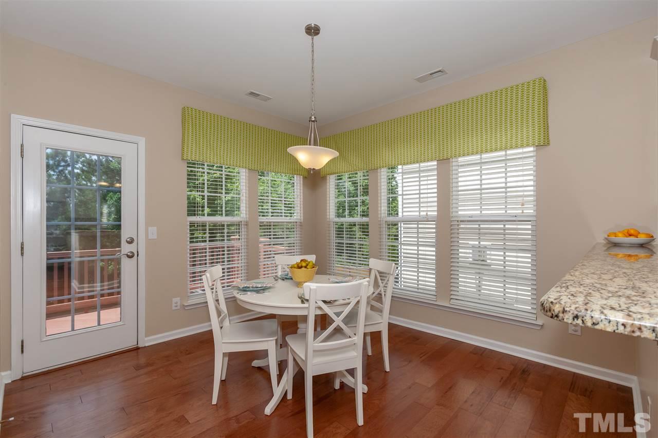 7331 Brandon Allen Avenue Raleigh, NC 27613 - Photo 7 of 25 Light-filled breakfast area that leads to Trex-covered deck and view of flat backyard and tree buffers.