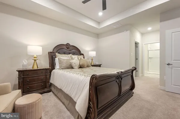 a bedroom with a bed and a lamp on dresser