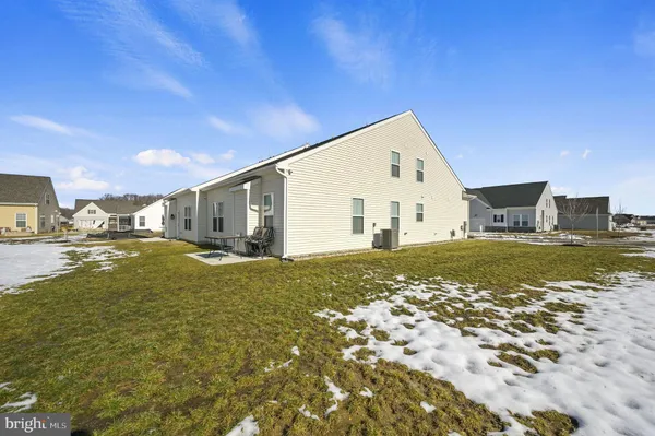 a view of a pool with lawn chairs and wooden fence