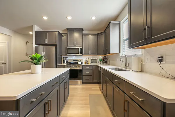 a kitchen with kitchen island granite countertop stainless steel appliances and sink