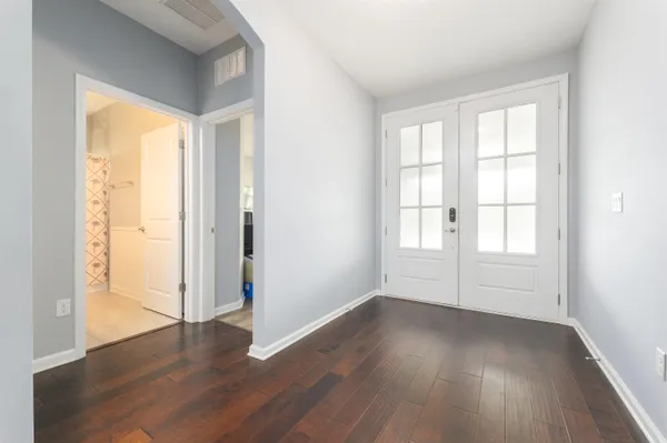 an empty room with wooden floor and windows