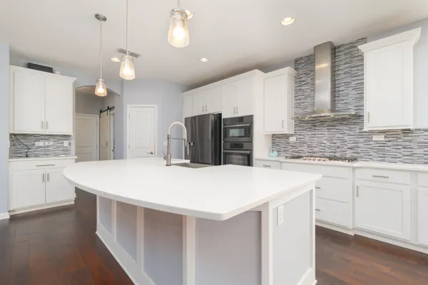 a kitchen with kitchen island a stove a sink and a refrigerator