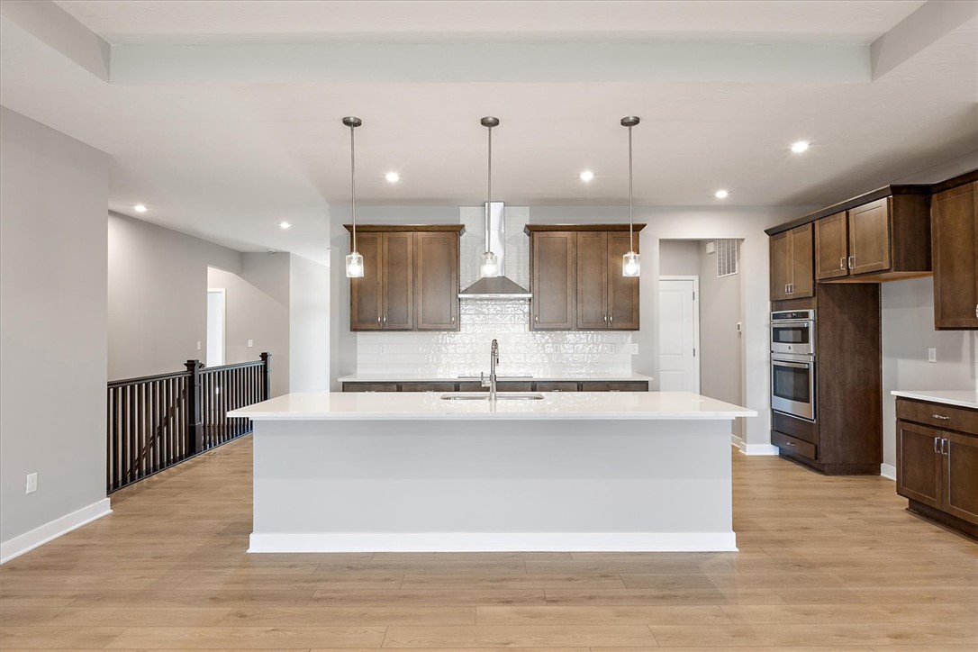 407 South Landon Lane Springfield, OH 45502 - Photo 3 of 30 A well-lit kitchen boasts warm wood cabinetry, a bright white subway tile backsplash, and a large island with pendant lighting.