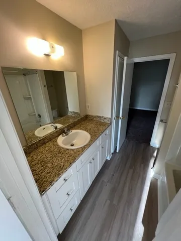 a bathroom with a granite countertop sink and a mirror